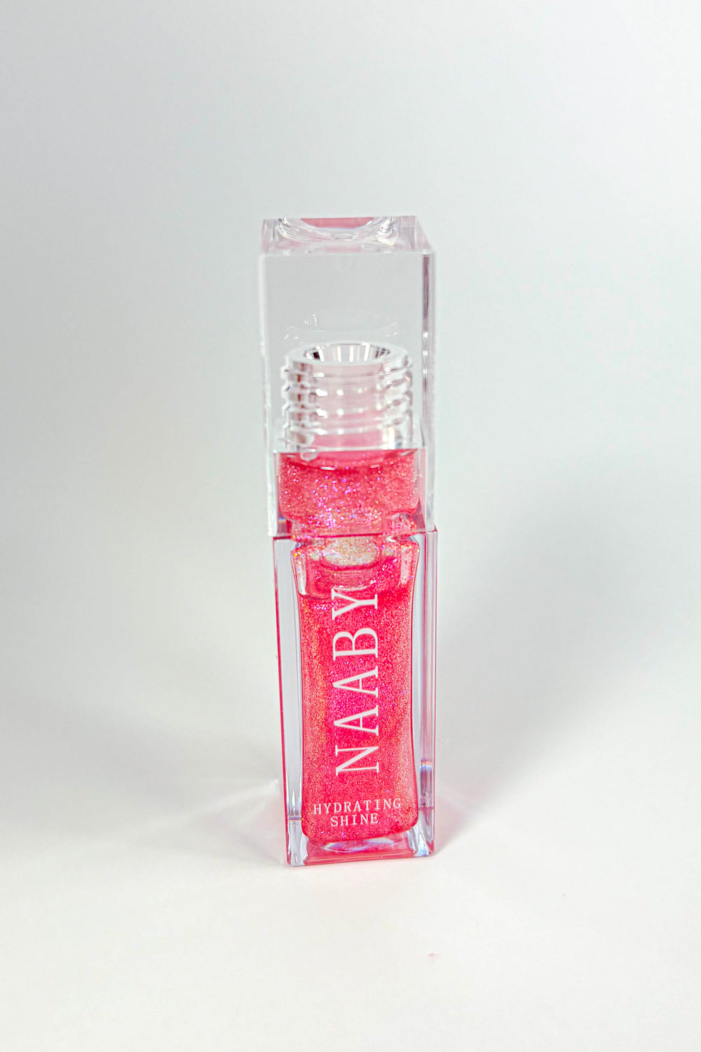 Pink lip gloss with 'NAABY' branding on a white background-Cinnamon Bun  Long-Lasting Hydrating Lip Gloss