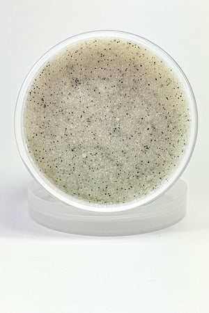 Jar of gray scrub with black specks on a white background. Cozy Glam – Foaming Sugar Body Scrub
