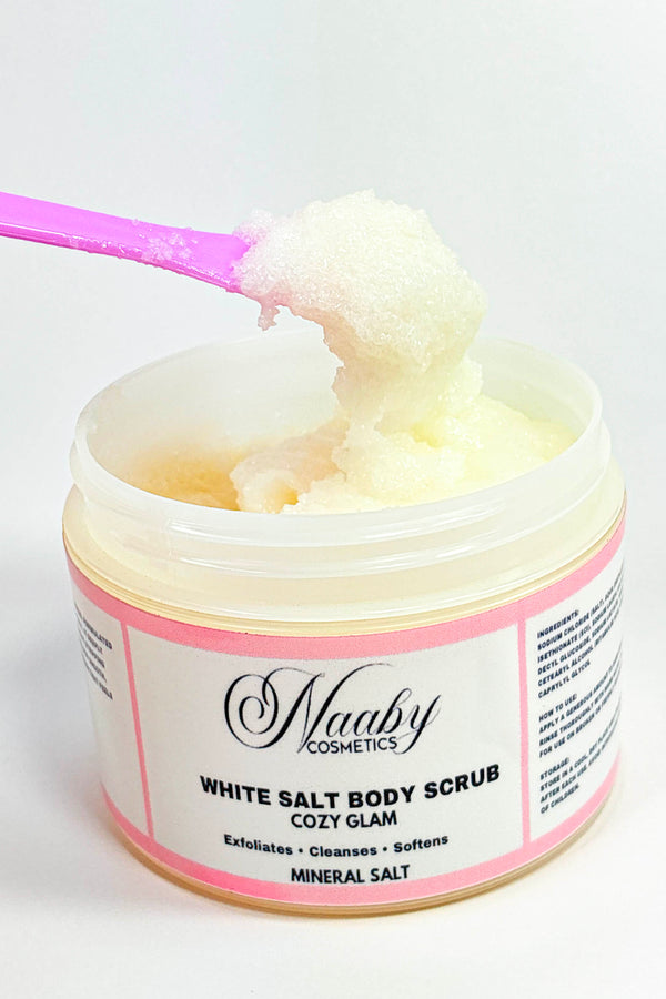 Jar of white salt body scrub with a pink spoon, branded as 'Naaby Cosmetics'.