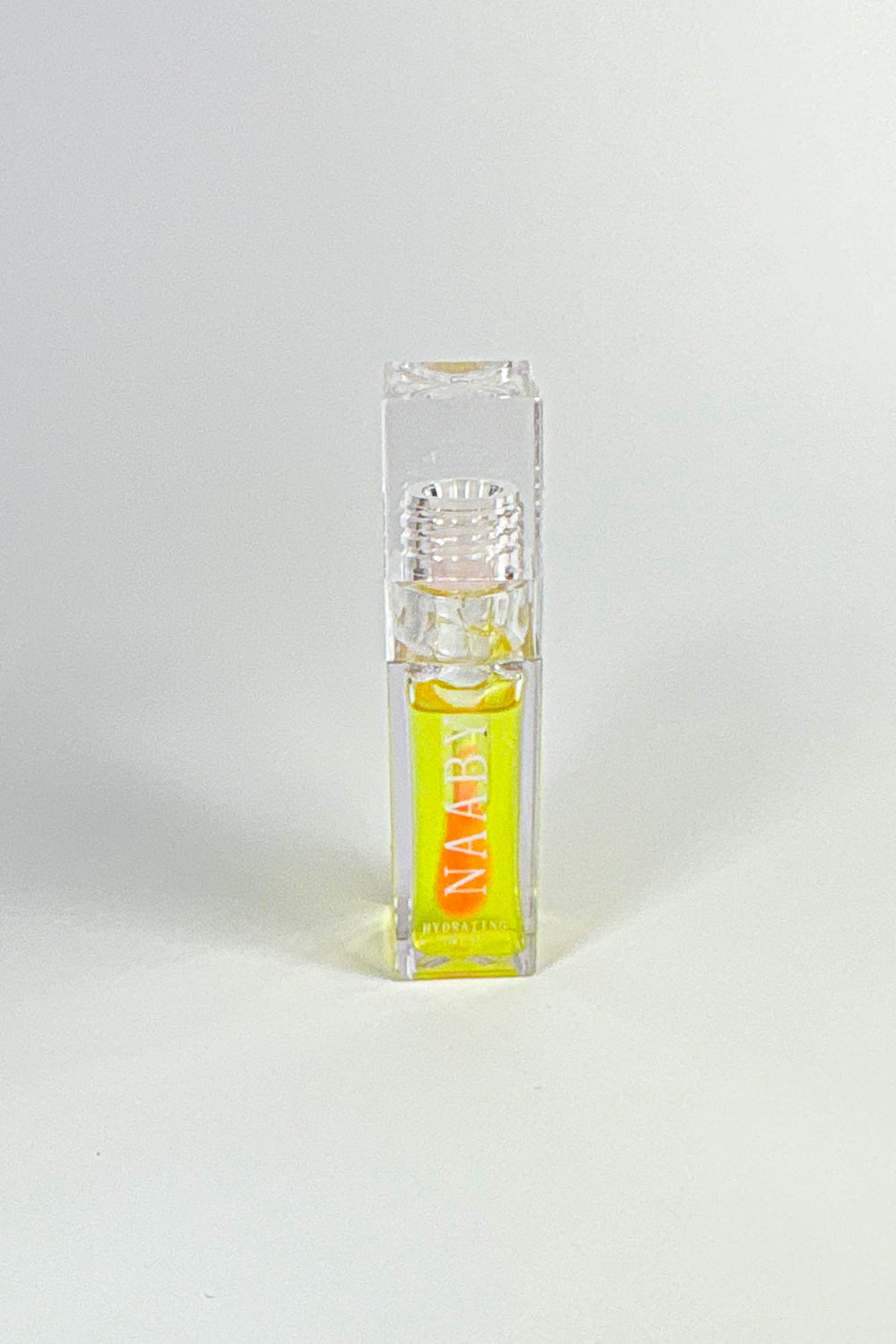 Small clear bottle with yellow liquid labeled 'NAABY' on a white background-Golden Glow color changing lip oil