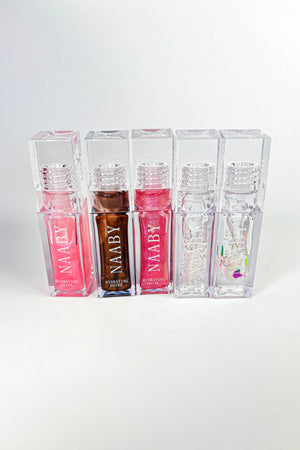 Set of NAABY lip glosses in clear containers on a white background
