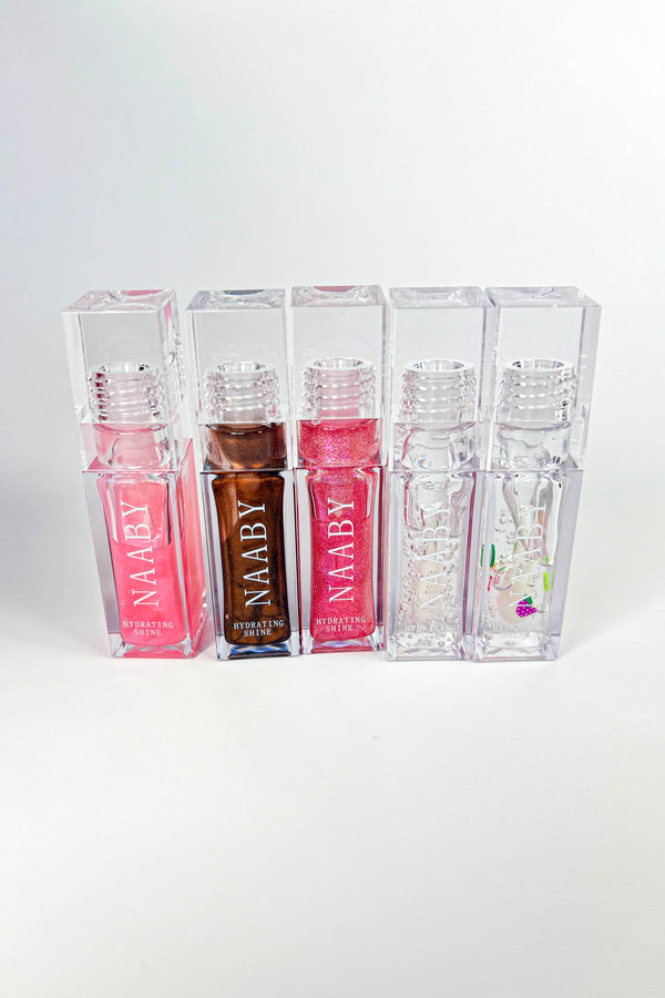 Set of NAABY lip glosses in clear containers on a white background