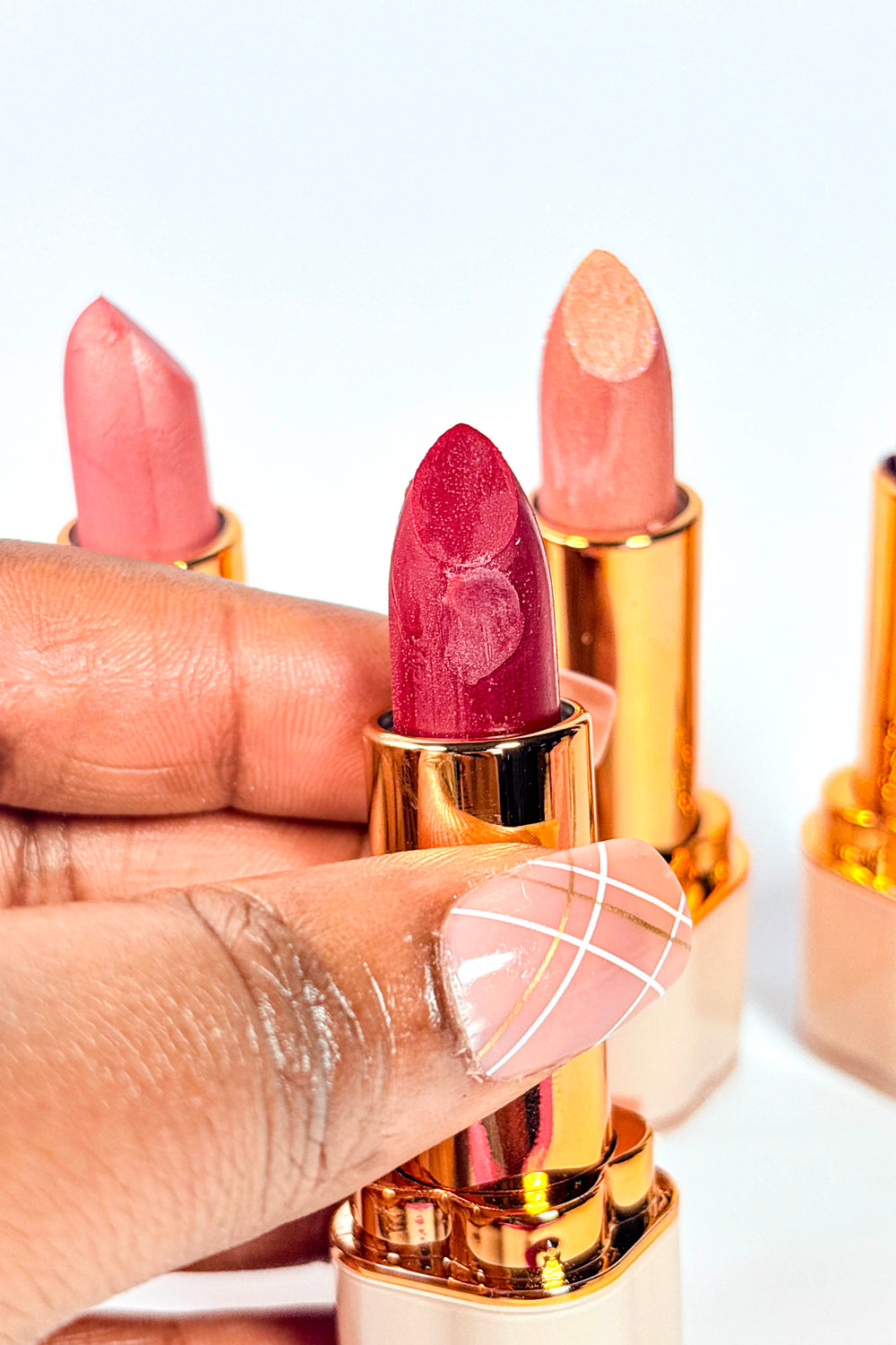 Naaby Cosmetics Lipstick with gold and beige casing on a white background