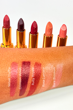 Set of lipsticks with swatches on an orange background