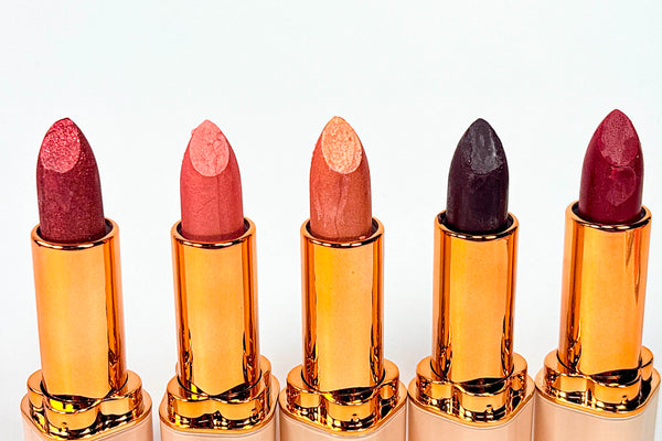 Set of six lipsticks with gold casings on a white background from Naaby cosmetics