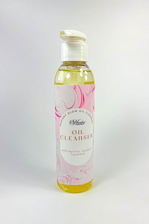 Bottle of oil cleanser with a floral label on a white background