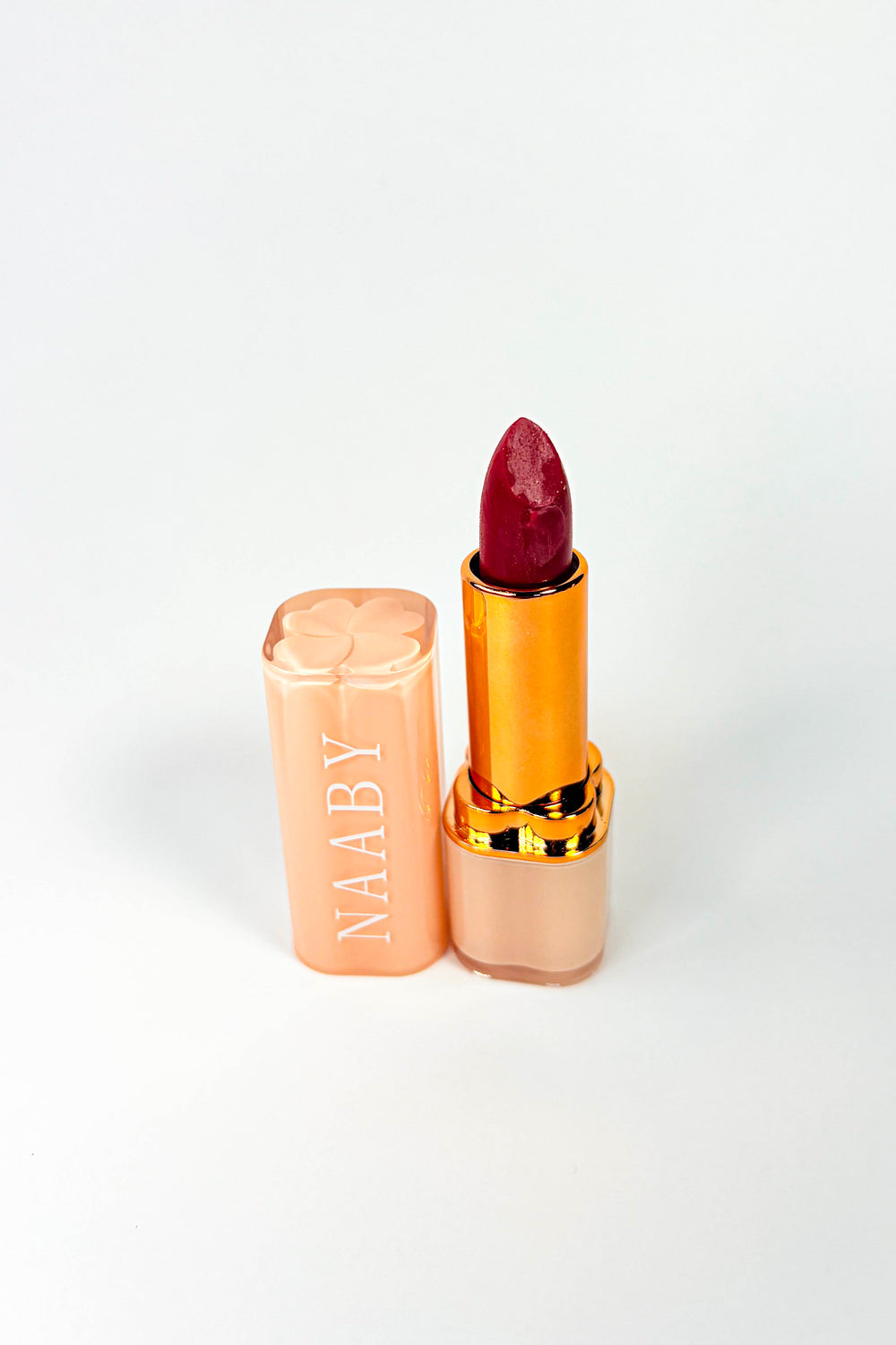 Naaby Cosmetics Lipstick with gold and beige casing on a white background