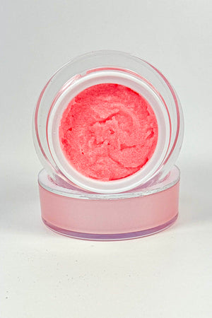 Pink cosmetic product in a clear container on a white background