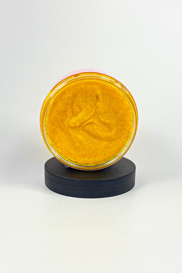 Round yellow object on a black stand against a white background-Turmeric Glow Scrub – Brightening Turmeric Sugar Scrub for Dark Spots