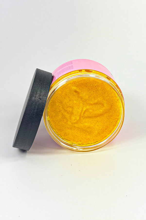 Jar of gold powder with a pink lid on a white background Turmeric_Glow_Scrub_Brightening_Turmeric_Sugar_Scrub_for_Dark_Spots