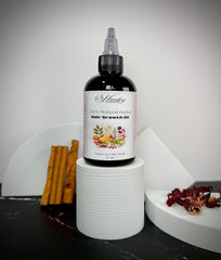 Bottle of natural herbal hair growth oil with cinnamon sticks and dried herbs on a white surface.