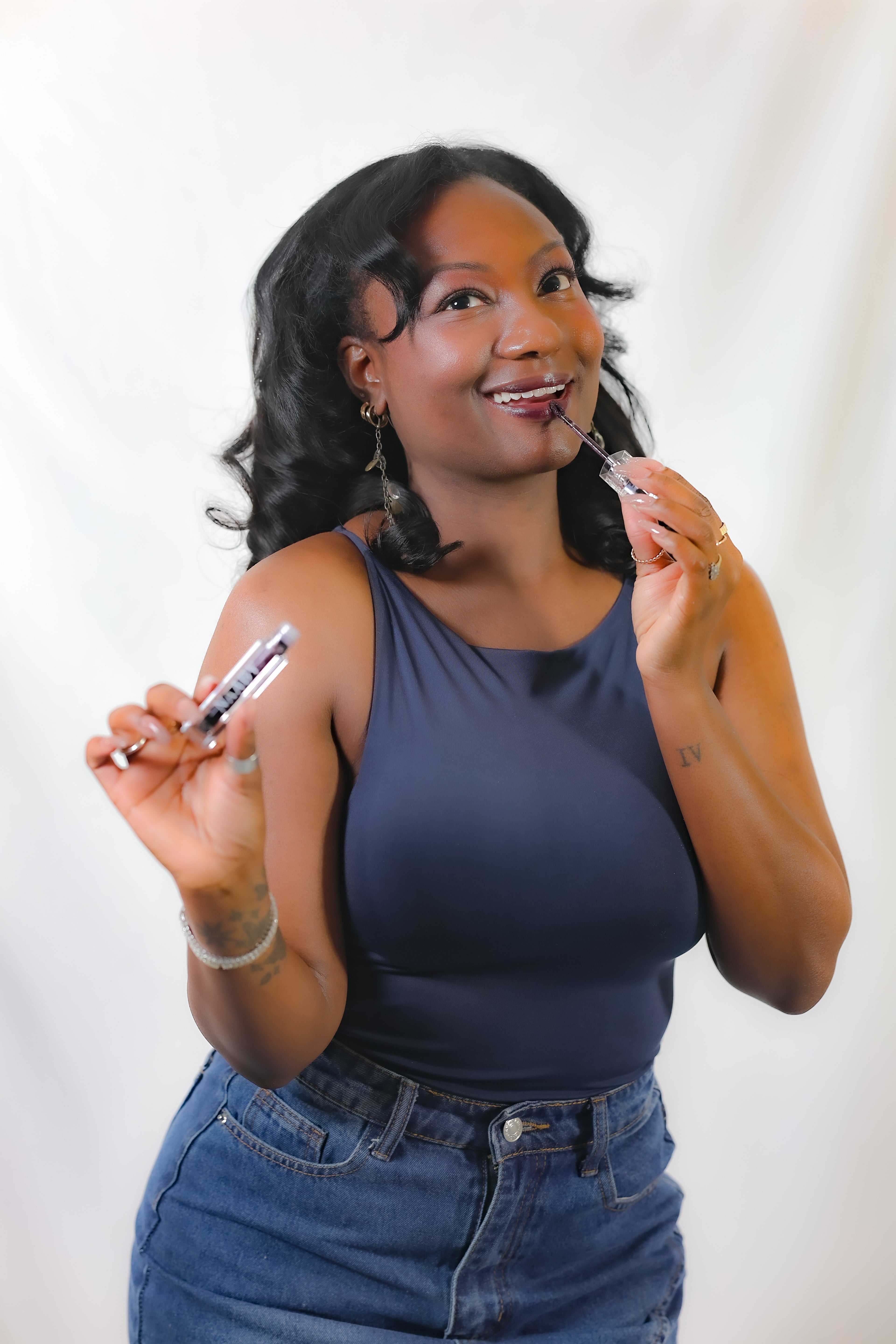 Woman holding a naaby cosmetics kotim lip tint  against a white background