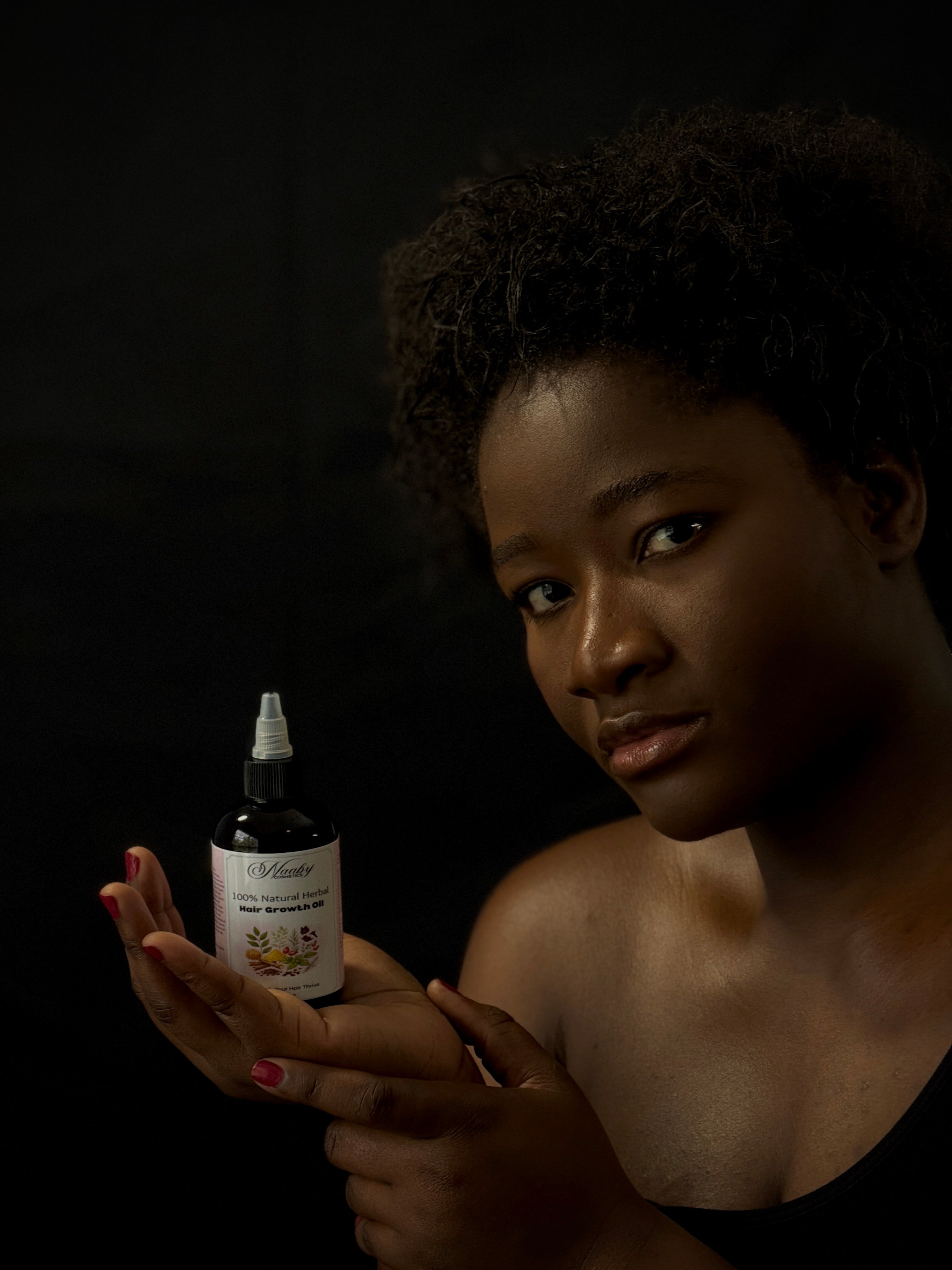 Woman holding a bottle of 'White Willow' product against a dark background
